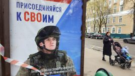 Illustrative photo: A woman pushes a stroller past a military propaganda billboard in Moscow, 2024. Photo: Contributor/Getty Images.