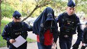 Police escort the truck driver accused of causing the crash as he heads for questioning. Photo: PAP/Adam Warżawa