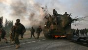 Georgian soldiers escape a burning armoured vehicle on the road to Tbilisi in August 2008. Photo: Uriel Sinai/Getty Images