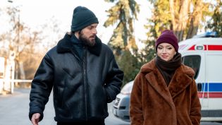 Na pierwszym zdjęciu Romek (Izydor Łobacz) i Britney (Paulina Zwierz) idą razem zimową ulicą, ubrani w grube kurtki i czapki. Scena pochodzi z odcinka 717 serialu „Na sygnale”, dostępnego w TVP VOD.