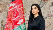 Nilofar Ayoubi stands next to an Afghan flag at the Women's Summit. Photo via Nilofar Ayoubi