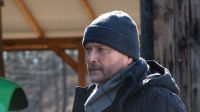 Na zdjęciu mężczyzna w czapce i szaliku. Ma krótki zarost. To ojciec Mateusz, którego gra Artur Żmijewski. Odc. 424 serialu „Ojciec Mateusz'" oglądaj w TVP VOD