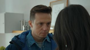 Para – kobieta i mężczyzna znajduje się w kuchni. Bliski plan. Za mężczyzną, który z uwagą i napięciem wpatruje się w kobietę, widać kuchenne sprzęty. Widzimy tylko tył głowy kobiety. Odc. 3194 „Barw szczęścia” oglądaj online w TVP VOD.   
