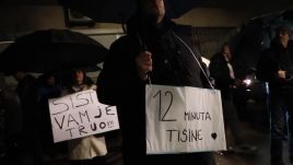 Protestors hold banners that say: "your system is rotten" and "12 minutes of silence (for shooting victims)". Photo: Reuters