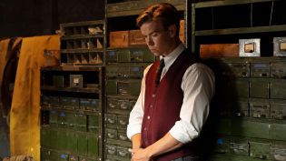 Młody chłopak stoi zamyślony w białej koszuli i czerwonej kamizelce. To Bobby, w tej roli Will Poulter. Serial Dlaczego nie Evans? dostępny jest w TVP VOD.